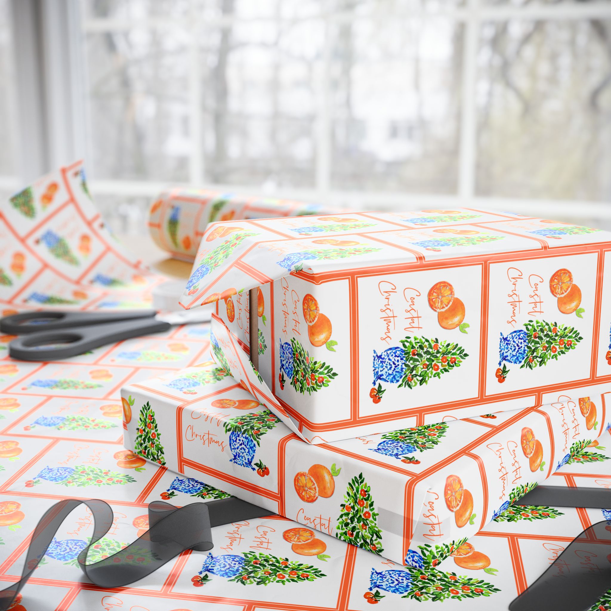Citrus orange tree wrapping paper with watercolor orange trees in blue and white chinoiserie pots and Coastal Christmas script by Laura Trevey, gift wrap in a holiday wrapping scene