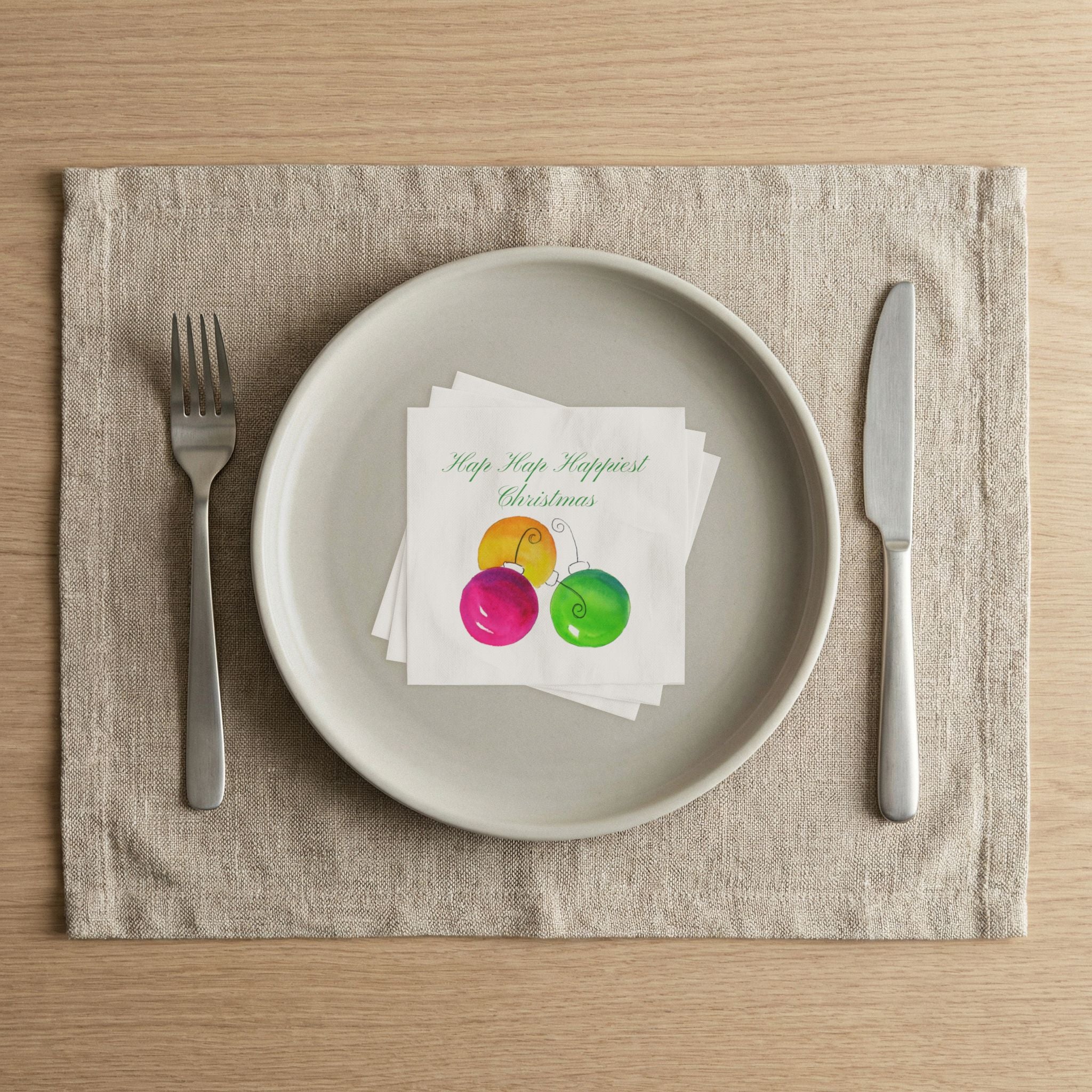 Hap Hap Happiest Christmas cocktail napkins on a linen placemat place setting