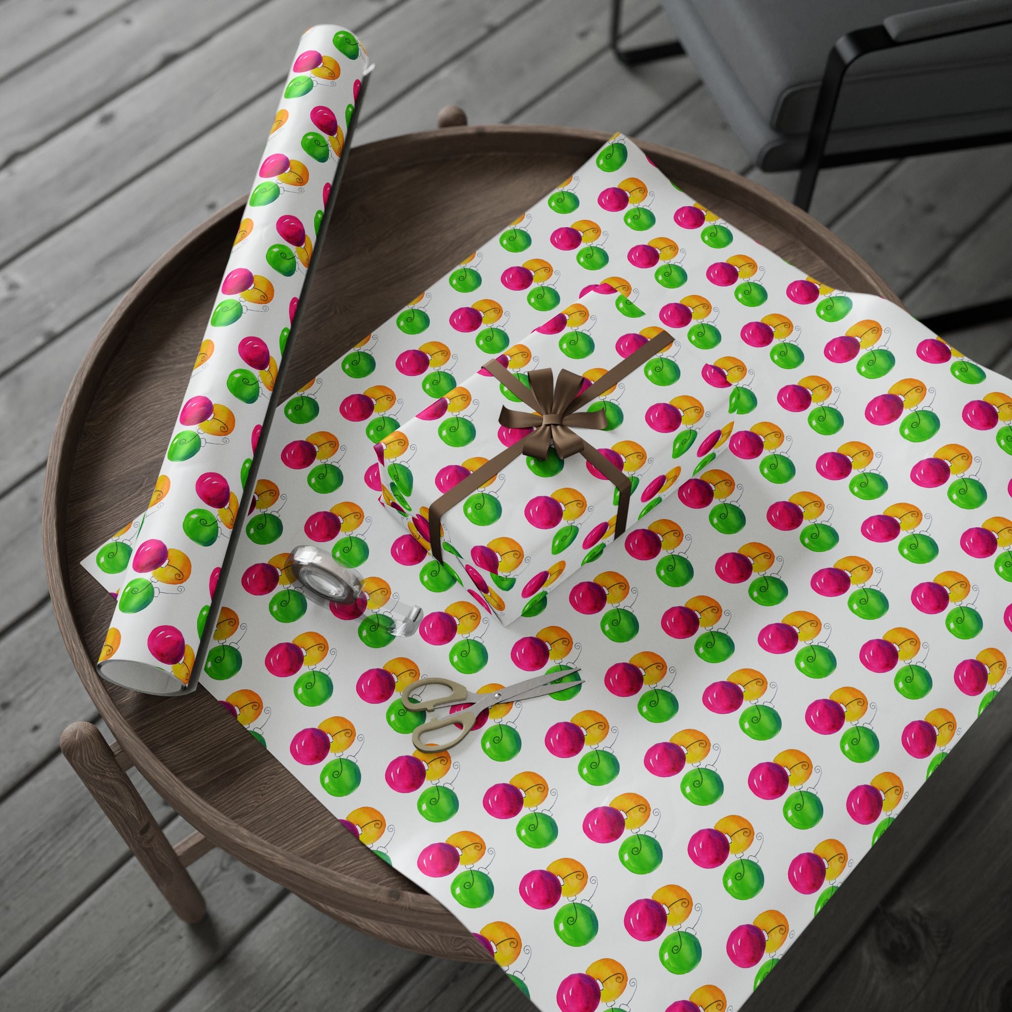 Watercolor Christmas Ornament Wrapping Paper | Pink & Lime Holiday Gift Wrap Roll – roll and wrapped gift with a gold ribbon bow on a round wooden tray