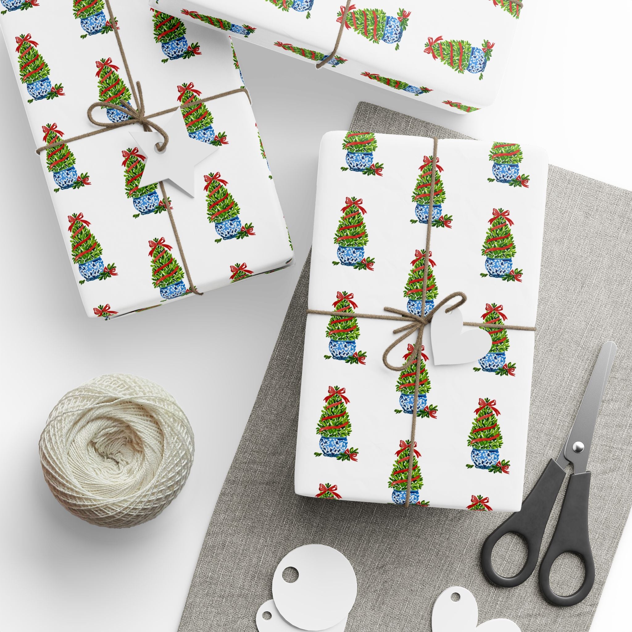 Christmas topiary wrapping paper with watercolor boxwood trees in blue and white chinoiserie pots by Laura Trevey, gifts wrapped with string and gift tags