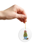 Hand holding the round boxwood topiary watercolor ornament