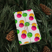 Watercolor Christmas Ornament Wrapping Paper | Pink & Lime Holiday Gift Wrap Roll – wrapped gift tied with twine on evergreen branches with pinecones