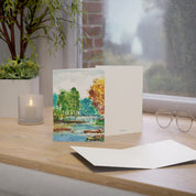 A River Runs Through It watercolor greeting card, standing on a windowsill desk with envelope