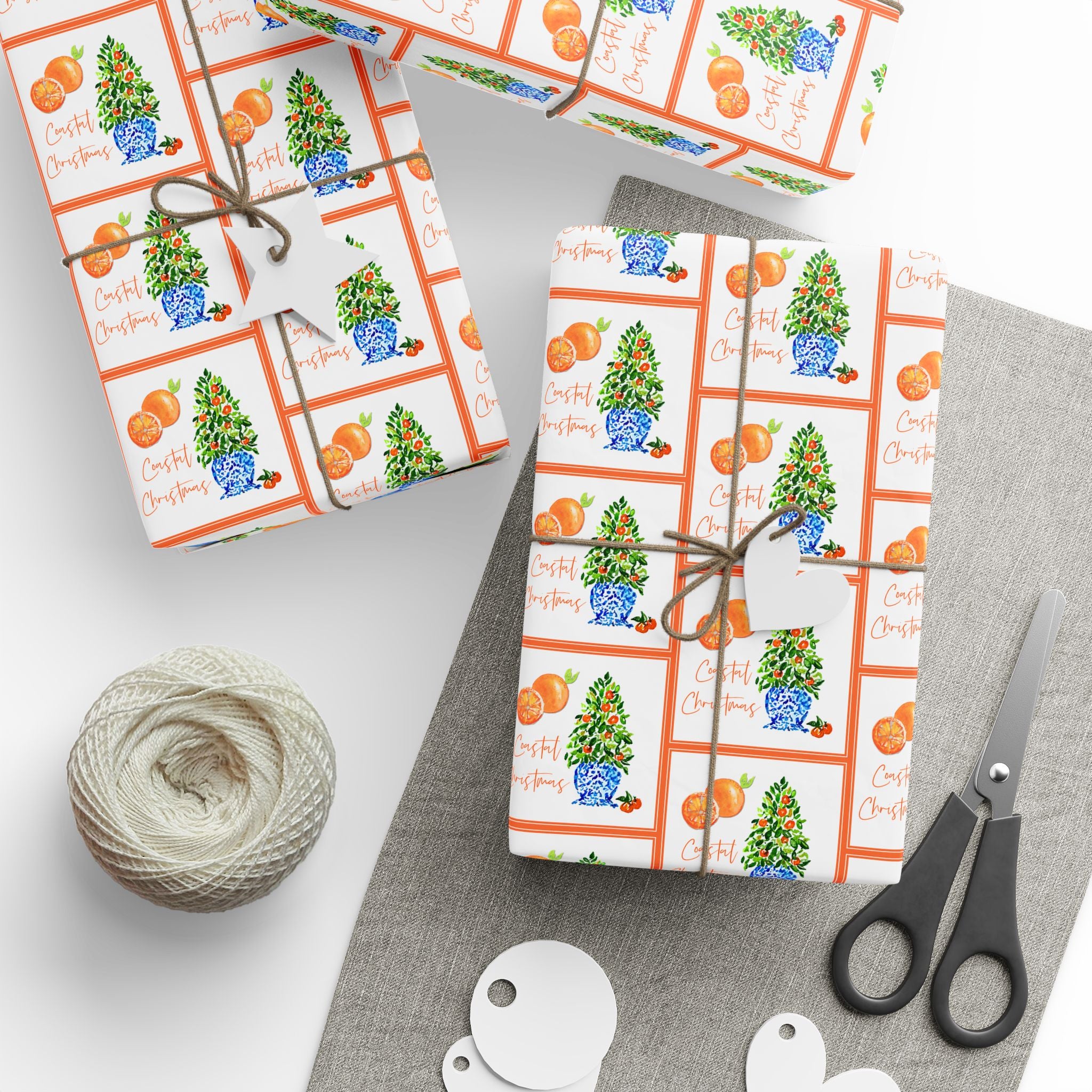 Citrus orange tree wrapping paper with watercolor orange trees in blue and white chinoiserie pots and Coastal Christmas script by Laura Trevey, gifts wrapped with string and gift tags
