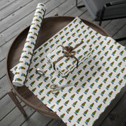 Christmas topiary wrapping paper with watercolor boxwood trees in blue and white chinoiserie pots by Laura Trevey, full sheet with a wrapped gift on a wooden table