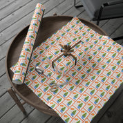 Citrus orange tree wrapping paper with watercolor orange trees in blue and white chinoiserie pots and Coastal Christmas script by Laura Trevey, full sheet with a wrapped gift on a wooden table