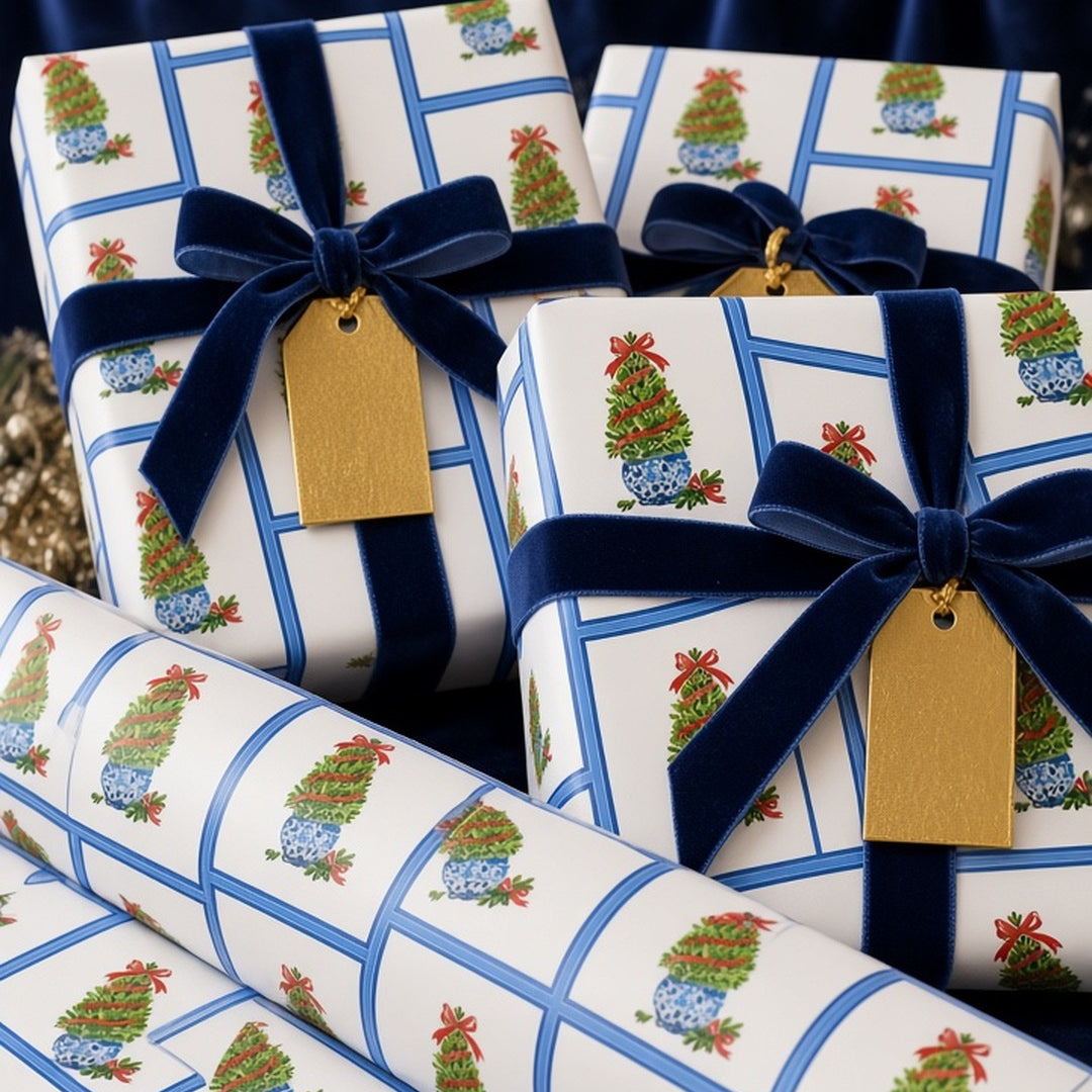 Blue and white chinoiserie topiary Christmas wrapping paper on gifts with navy velvet ribbon and gold tags