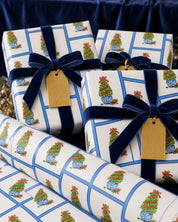 Blue and white chinoiserie topiary Christmas wrapping paper on gifts with navy velvet ribbon and gold tags