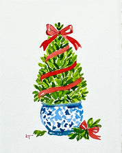 5x7 original watercolor of a boxwood Christmas topiary with a red ribbon and bow in a blue and white chinoiserie planter by Laura Trevey