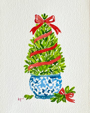 Close-up of a boxwood topiary watercolor painting with red ribbon, red bow and blue and white chinoiserie pot