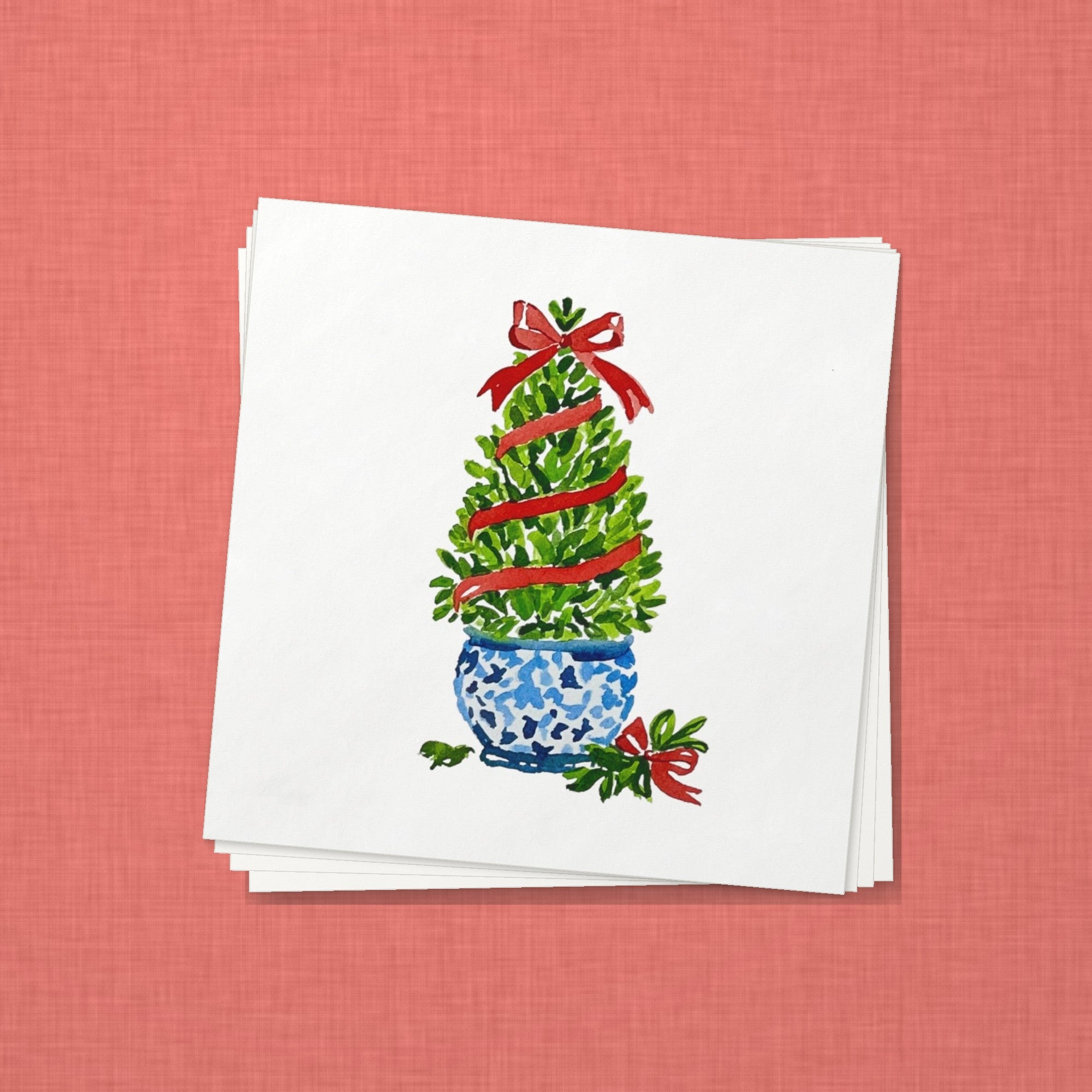 Boxwood Topiary Christmas Cocktail Napkins | Watercolor Holiday Paper Napkins – stack of cocktail napkins on coral red linen
