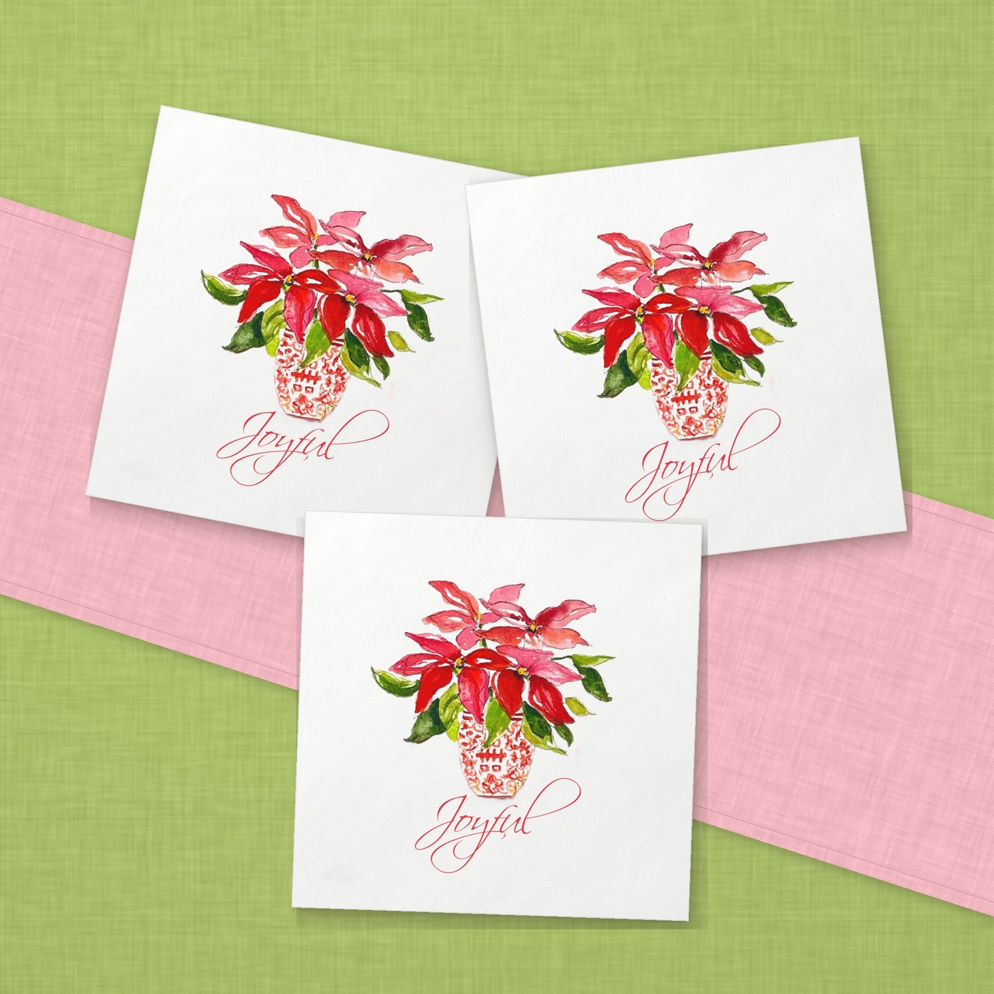 Joyful Poinsettia Christmas Cocktail Napkins | Watercolor Holiday Paper Napkins – paper napkins spread on lime green linen with a soft pink table runner