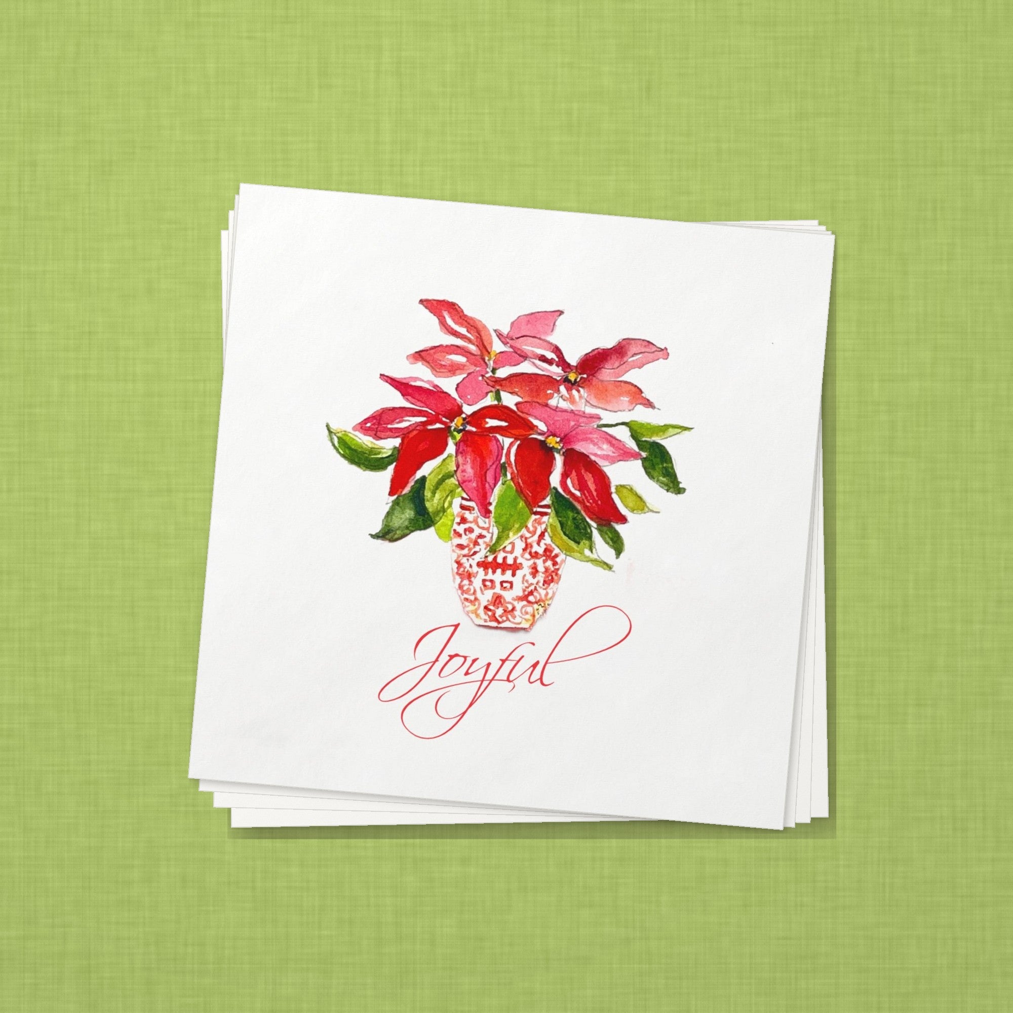 Joyful Poinsettia Christmas Cocktail Napkins | Watercolor Holiday Paper Napkins – stack of cocktail napkins on lime green linen