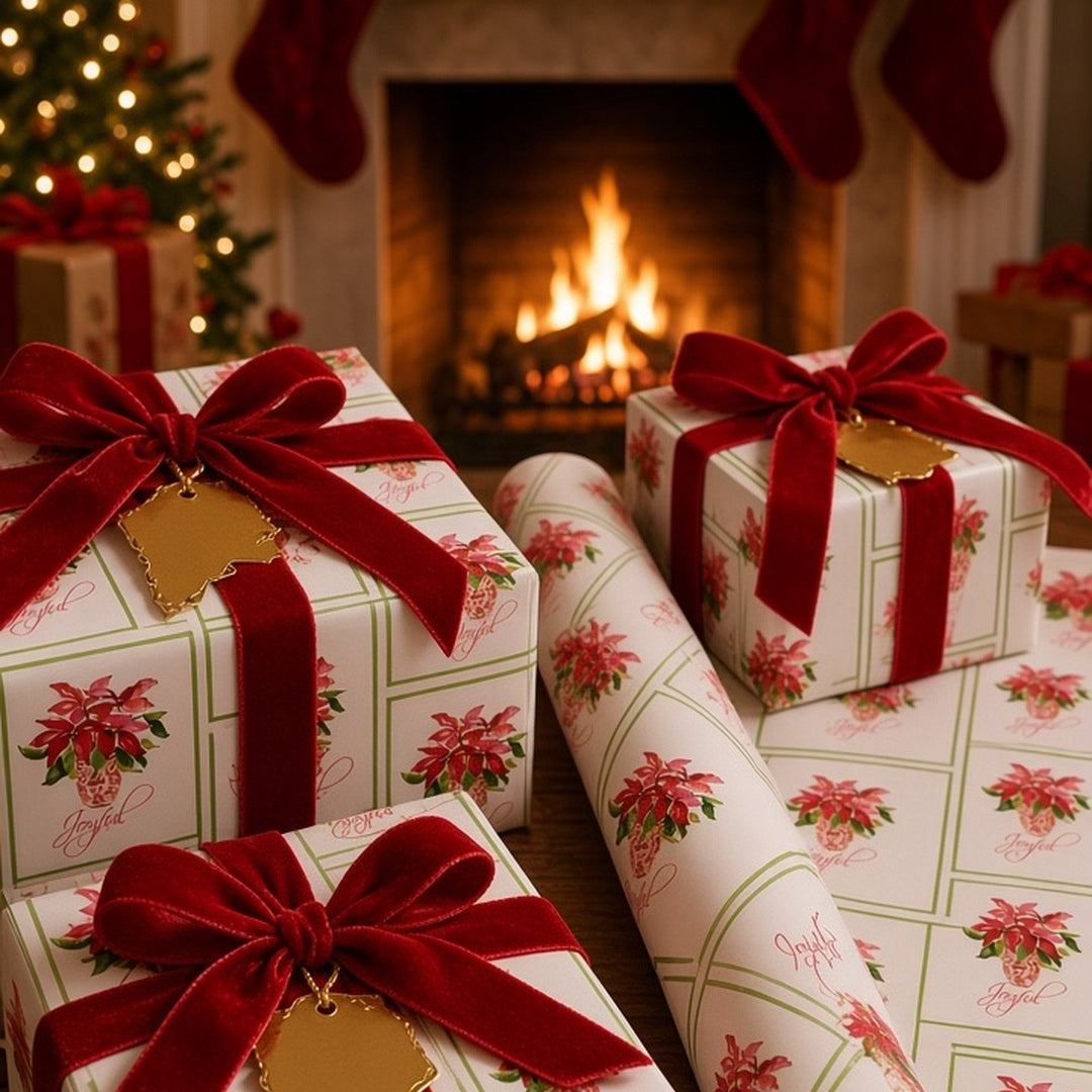 Joyful red poinsettia Christmas wrapping paper on gifts by a fireplace with red velvet ribbon