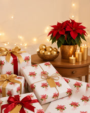 Red poinsettia Christmas wrapping paper on gifts with gold and red ribbon